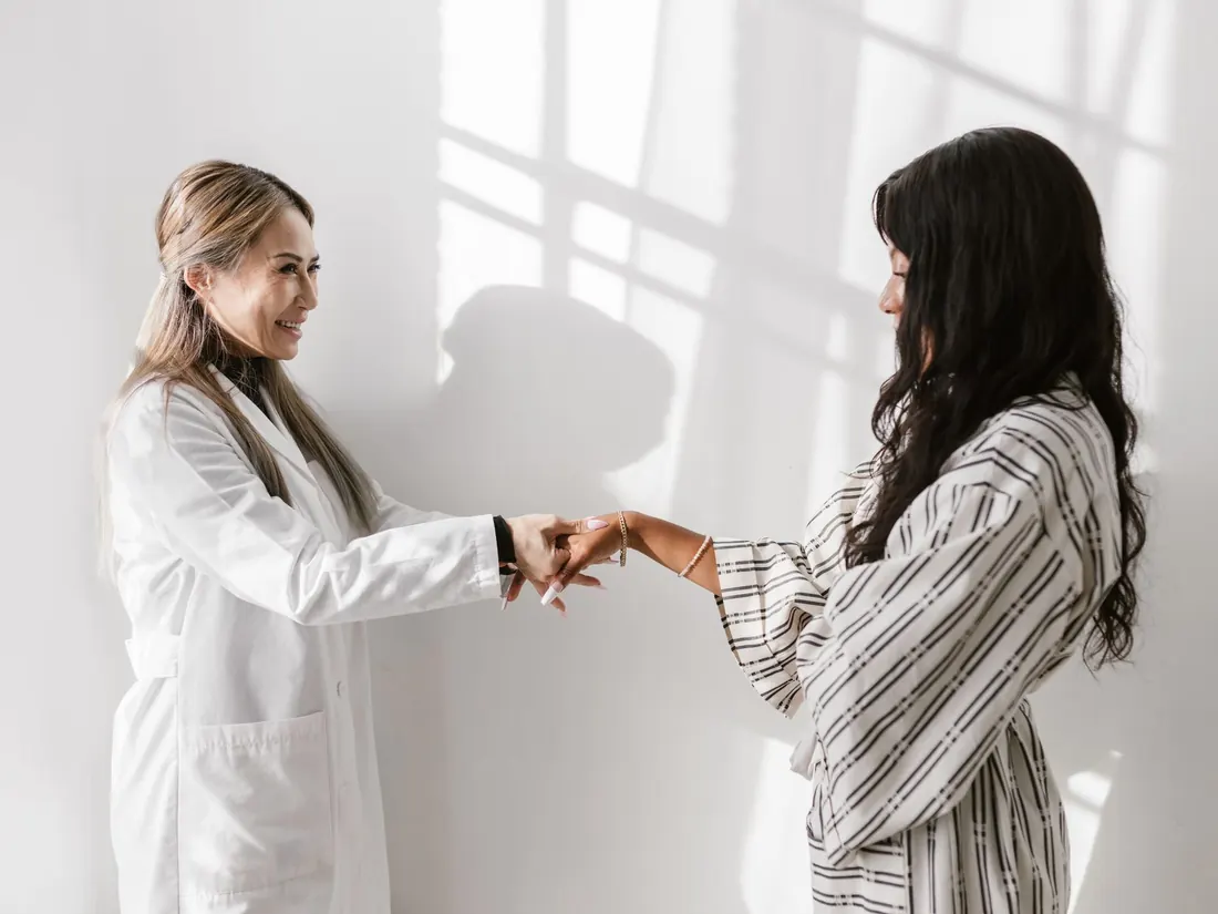 Paciente saludando a su doctora en el consultorio